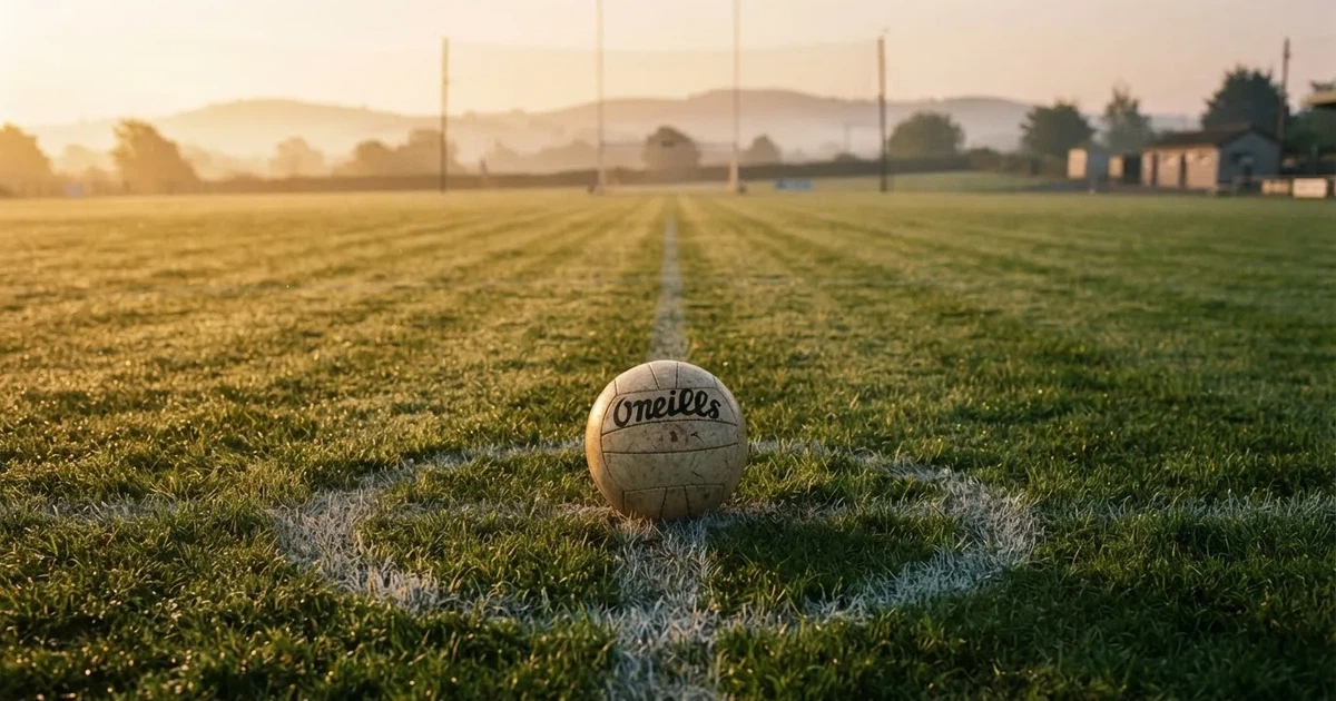 A ball on the centre spot of a grass pitch in morning light